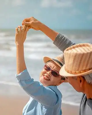 Pareja de adultos mayores bailando en la playa